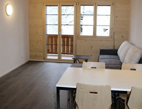 Gruppenhaus Sportlodge Gstaad Zimmer mit Tisch und Stühlen
