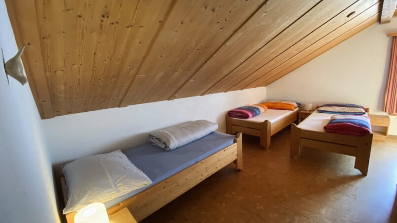Zwei-Bett-Zimmer im Gruppenhaus Steinbock in Val Müstair mit Holzdecke
